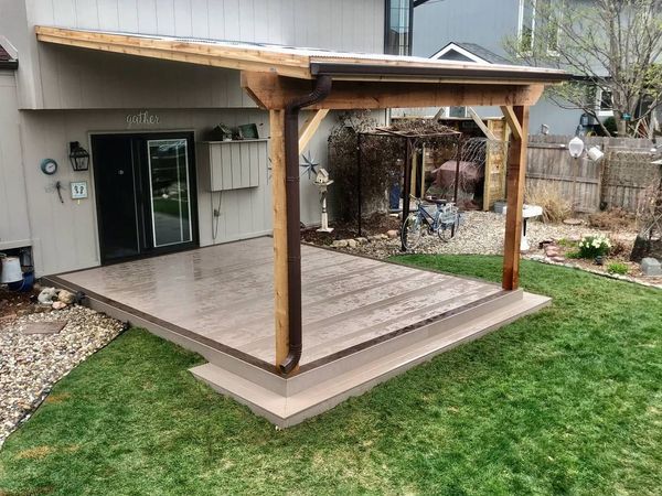 Two-level composite deck with pergola, outdoor seating zone, and recessed rail lighting, Omaha, NE