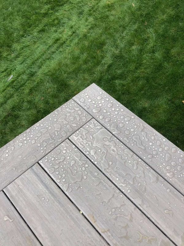 Custom L-shaped cedar deck with built-in corner bench and lighted post caps, Omaha, NE