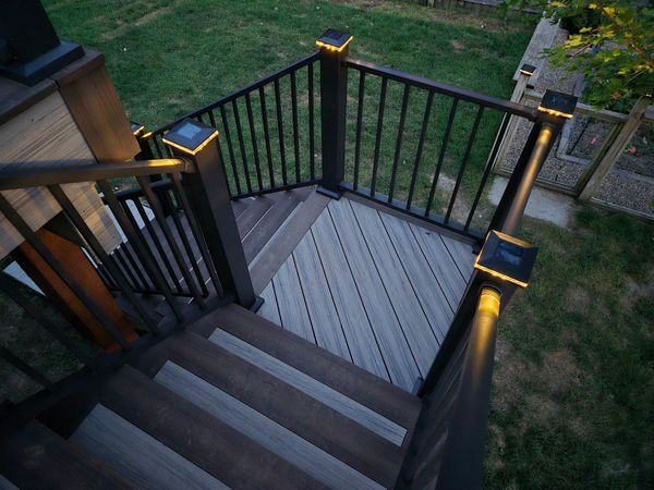 Composite deck addition with corner bench seating, built-in planters, and solar post cap lighting, Omaha, NE