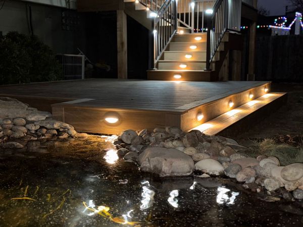 Custom cedar deck with horizontal slat privacy railing and low-voltage LED tread lighting, Omaha, NE