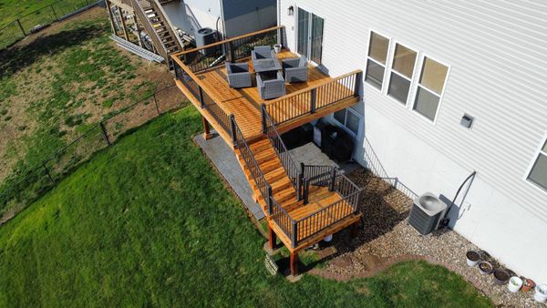 Wraparound composite deck with natural cedar accent trim and craftsman-style baluster railing, Gretna, NE