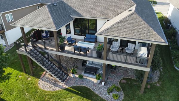 Cedar deck with pergola structure, hanging string lights, and decorative metal baluster railing, Omaha, NE