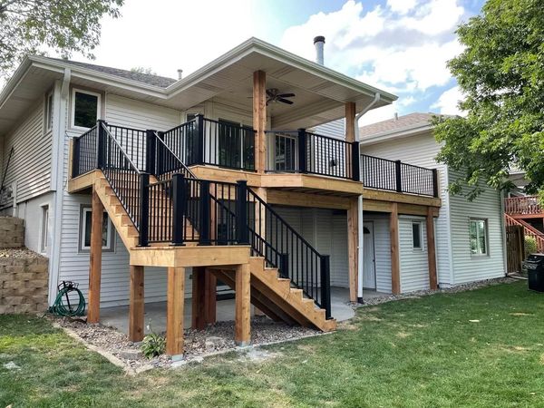 Elevated custom deck with stairs and black metal railing on an Omaha-area home